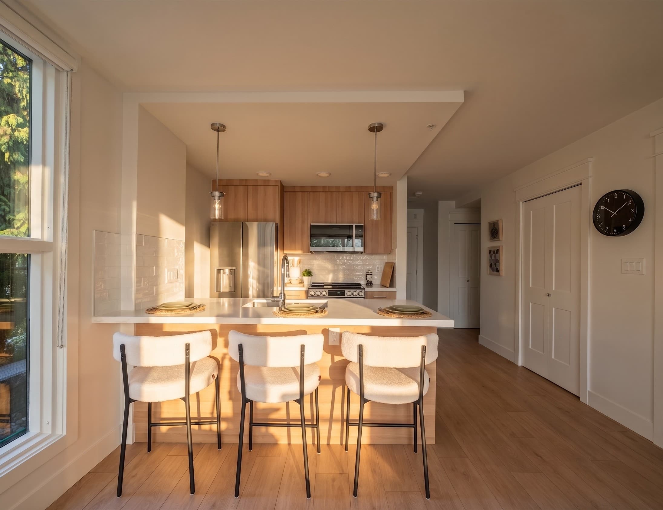 Luxora kitchen at golden hour, with dining bar and forest view